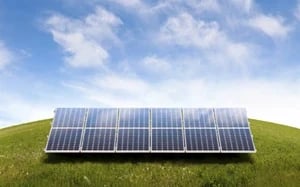 solar panels on top of a grass hill